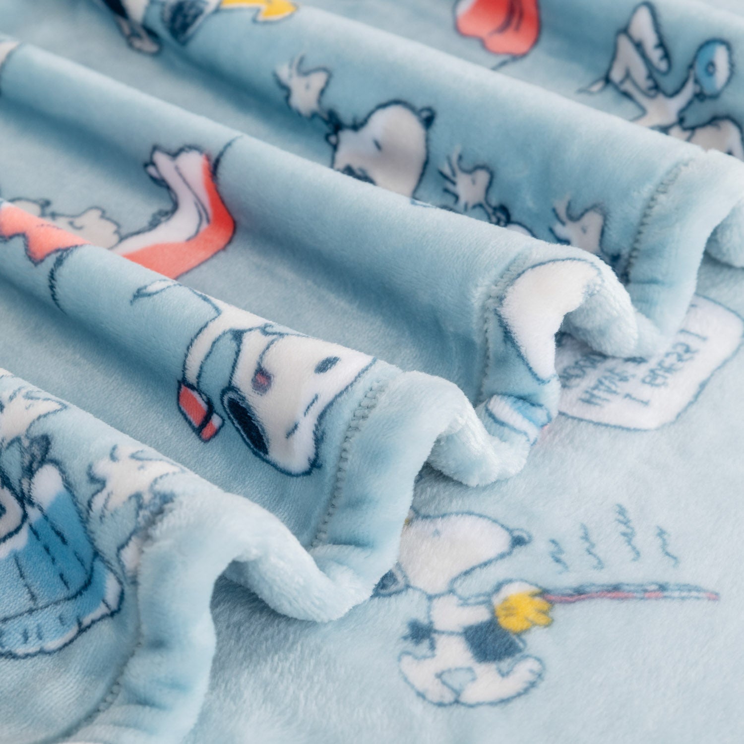 Close up of a blue Peanuts 75th Anniversary Throw. 