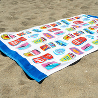 Colorful towel with cartoonish designs on a sandy surface