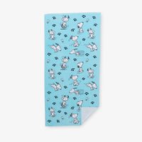 Blue Peanuts beach towel laid flat on a white surface.