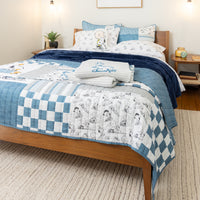 Bed with blue and white checkered quilt and cartoon-themed pillows in a bedroom setting.