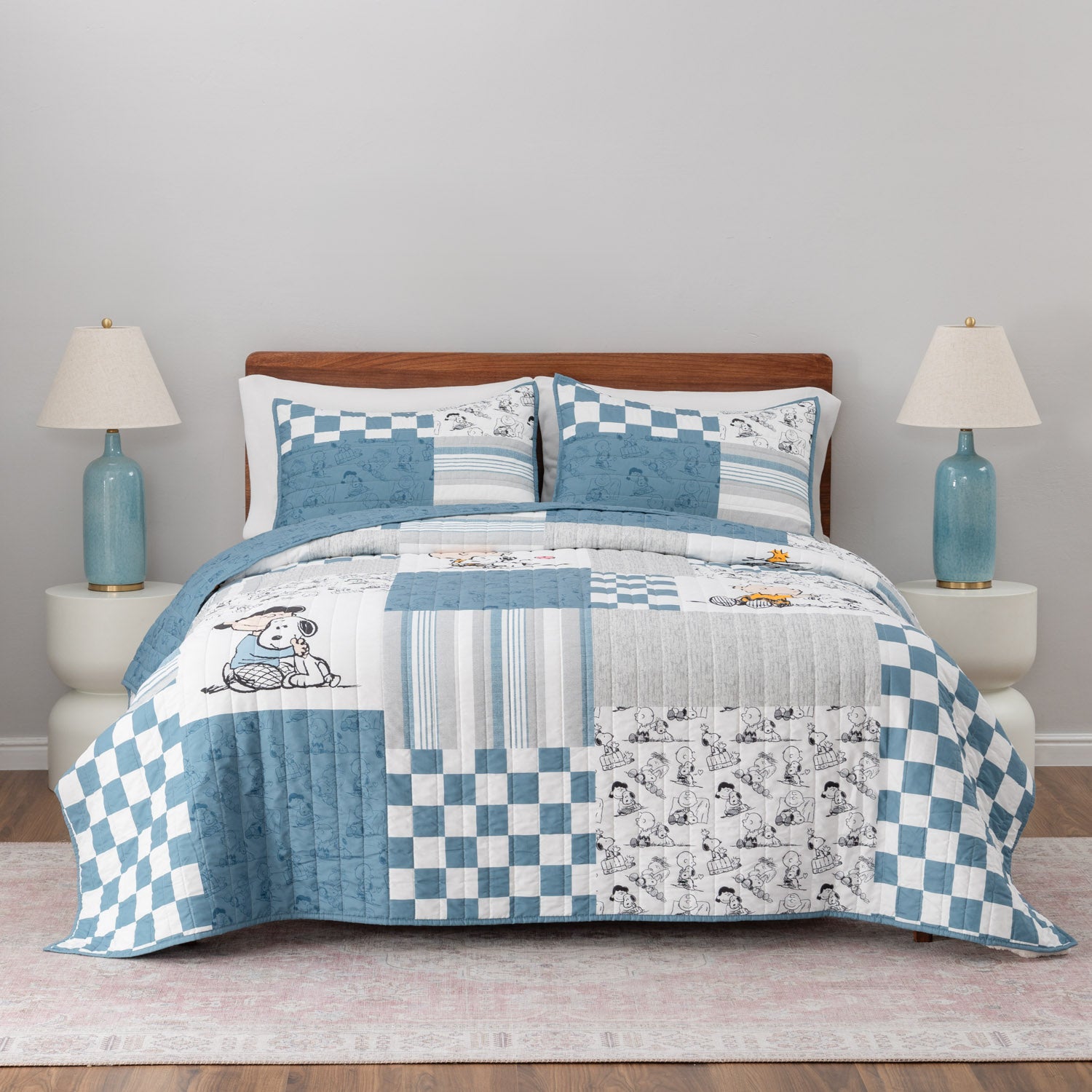 Peanuts patchwork quilt set dressed on a bed.