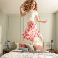 Young girl jumping on a bed in a bedroom