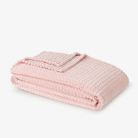 Pink textured blanket on a light gray background