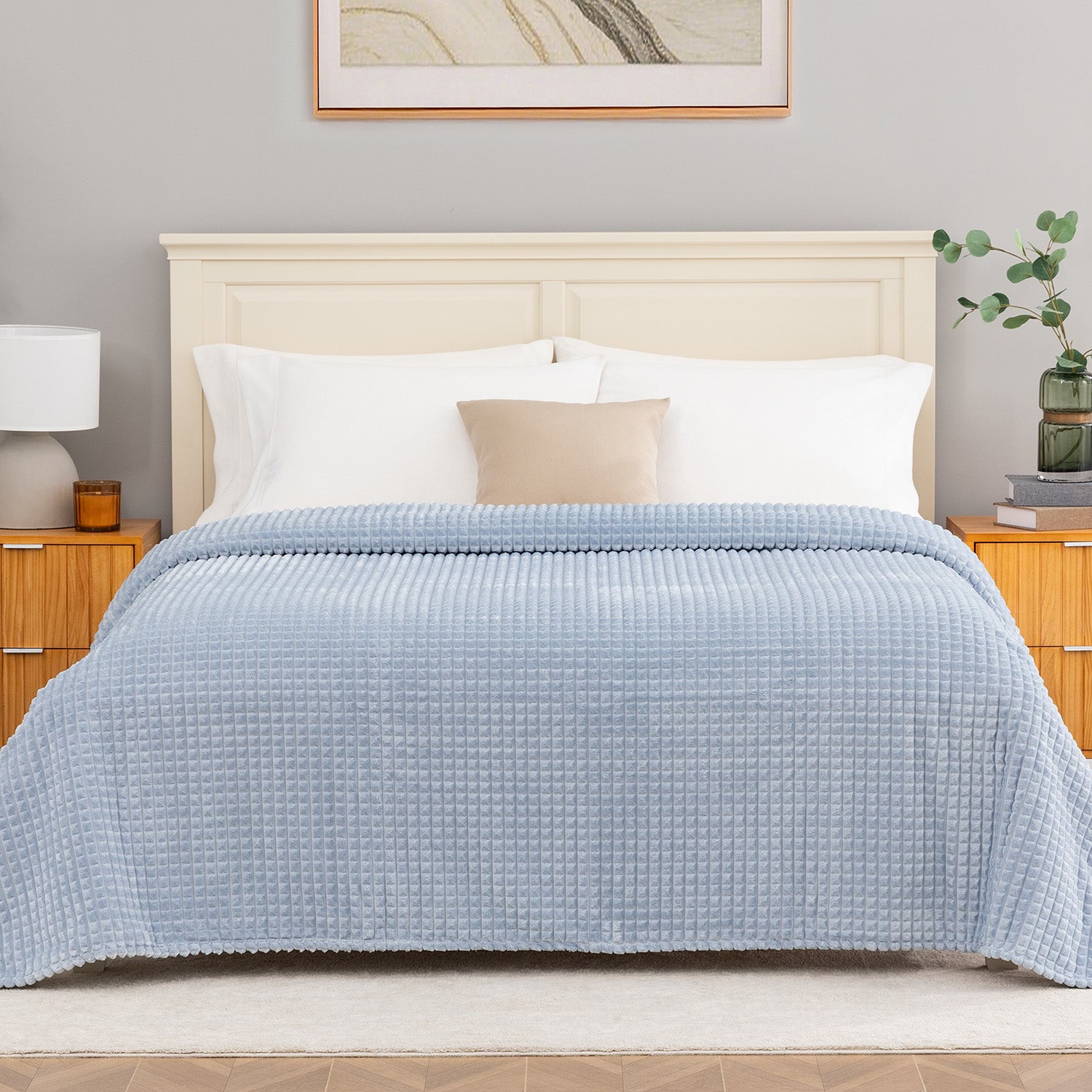 Blue waffle blanket decorated neatly on a bed.