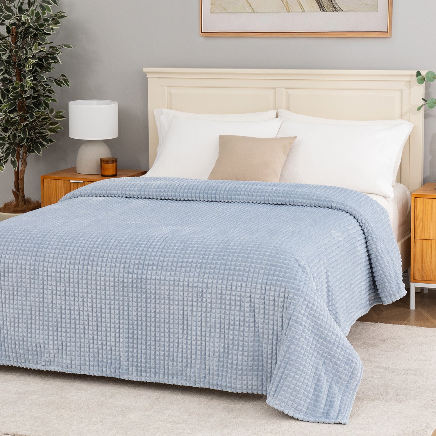 A blue waffle blanket decorated on a bed.