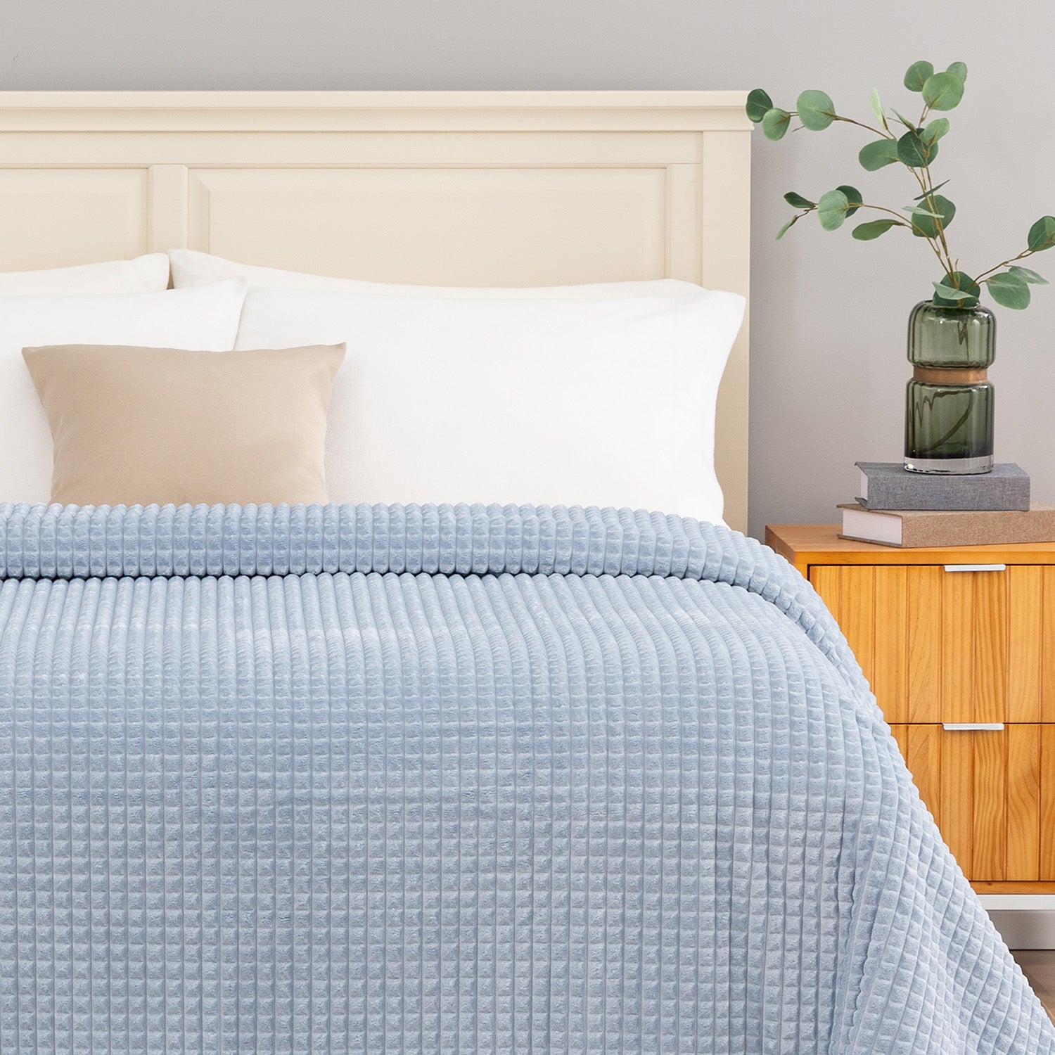 A blue waffle blanket decorated on a bed.