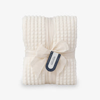 A cream VelvetLoft waffle blanket folded neatly on a white surface.