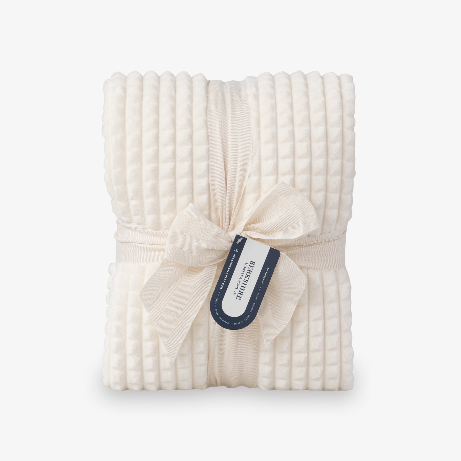 A cream VelvetLoft waffle blanket folded neatly on a white surface.