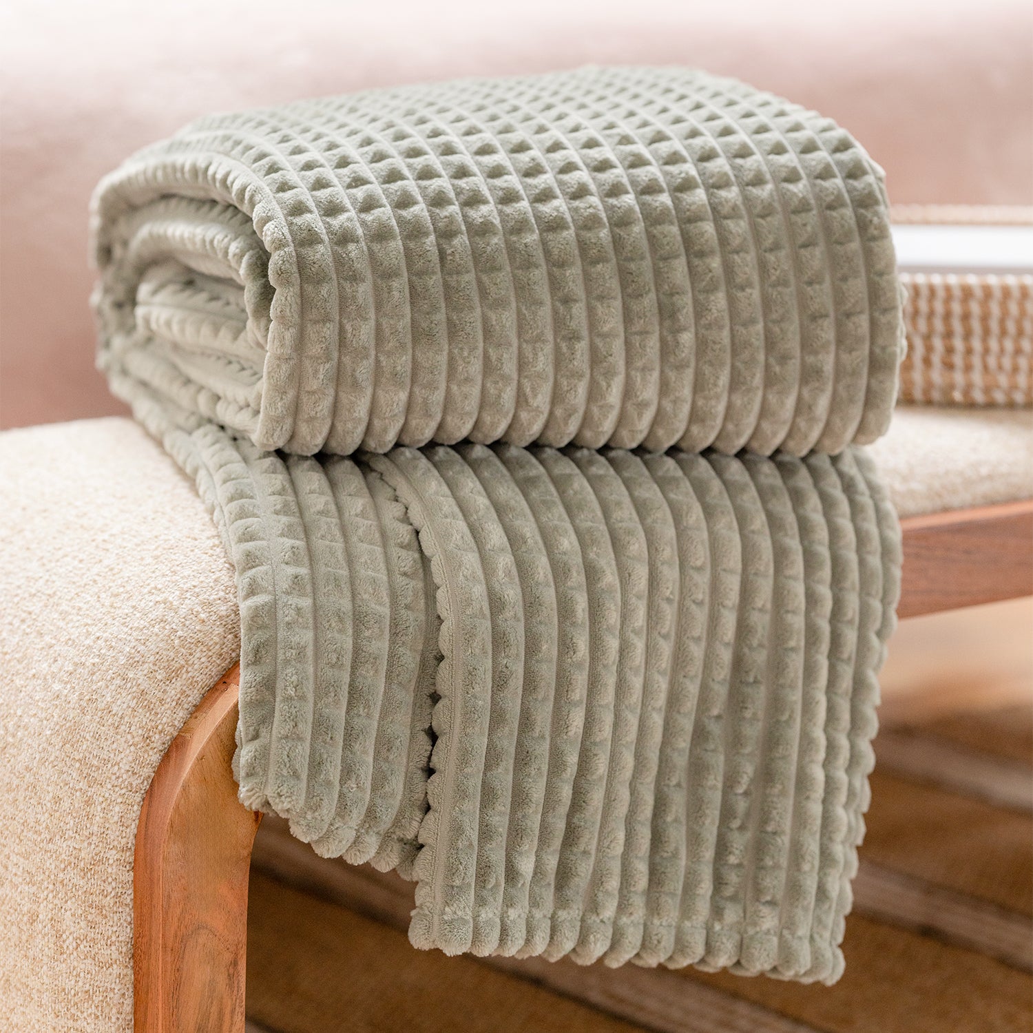Folded textured blanket on a chair with a blurred background