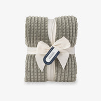 A sage green VelvetLoft waffle blanket folded neatly on a white surface.