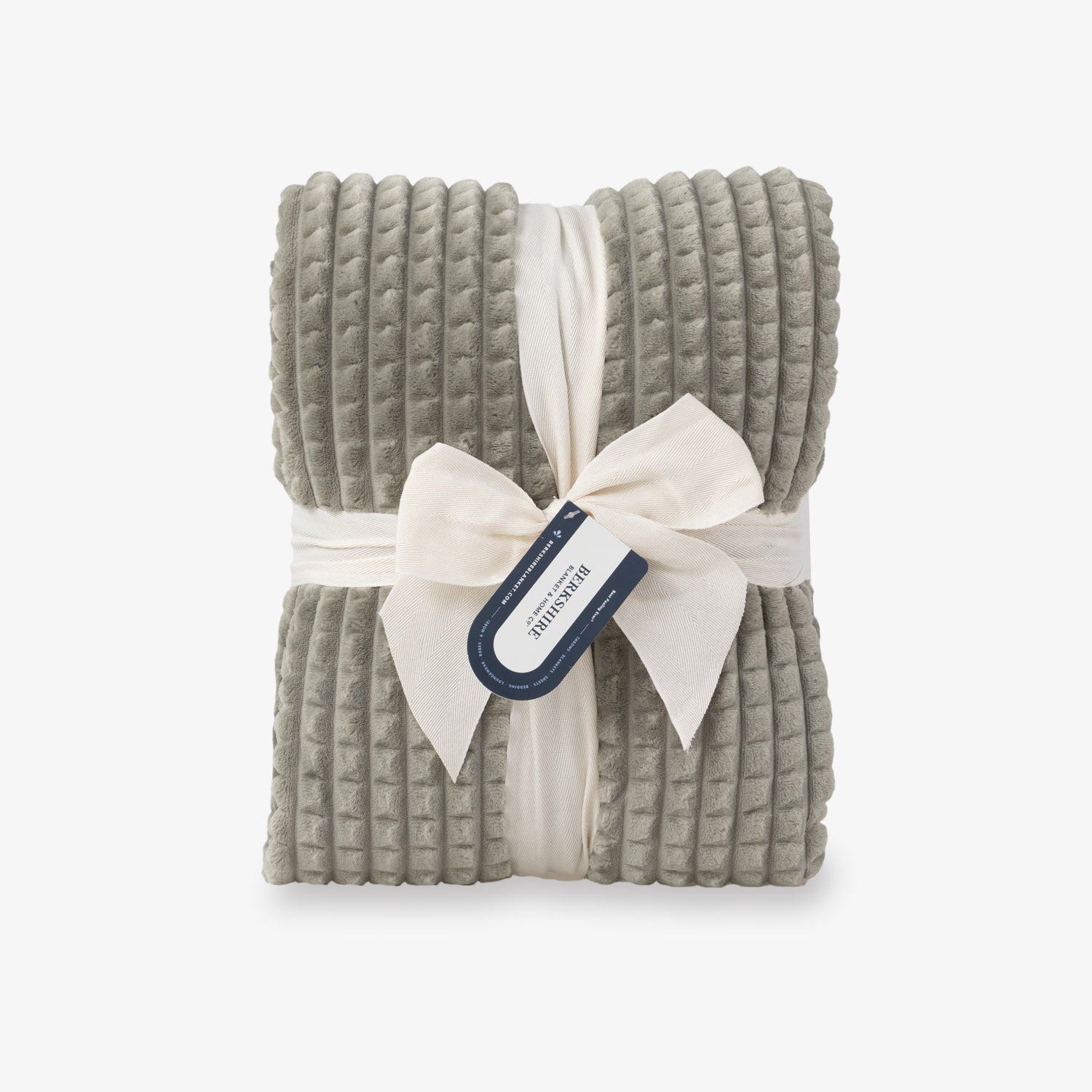 A sage green VelvetLoft waffle blanket folded neatly on a white surface.