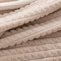 A close up of a tan waffle blanket.
