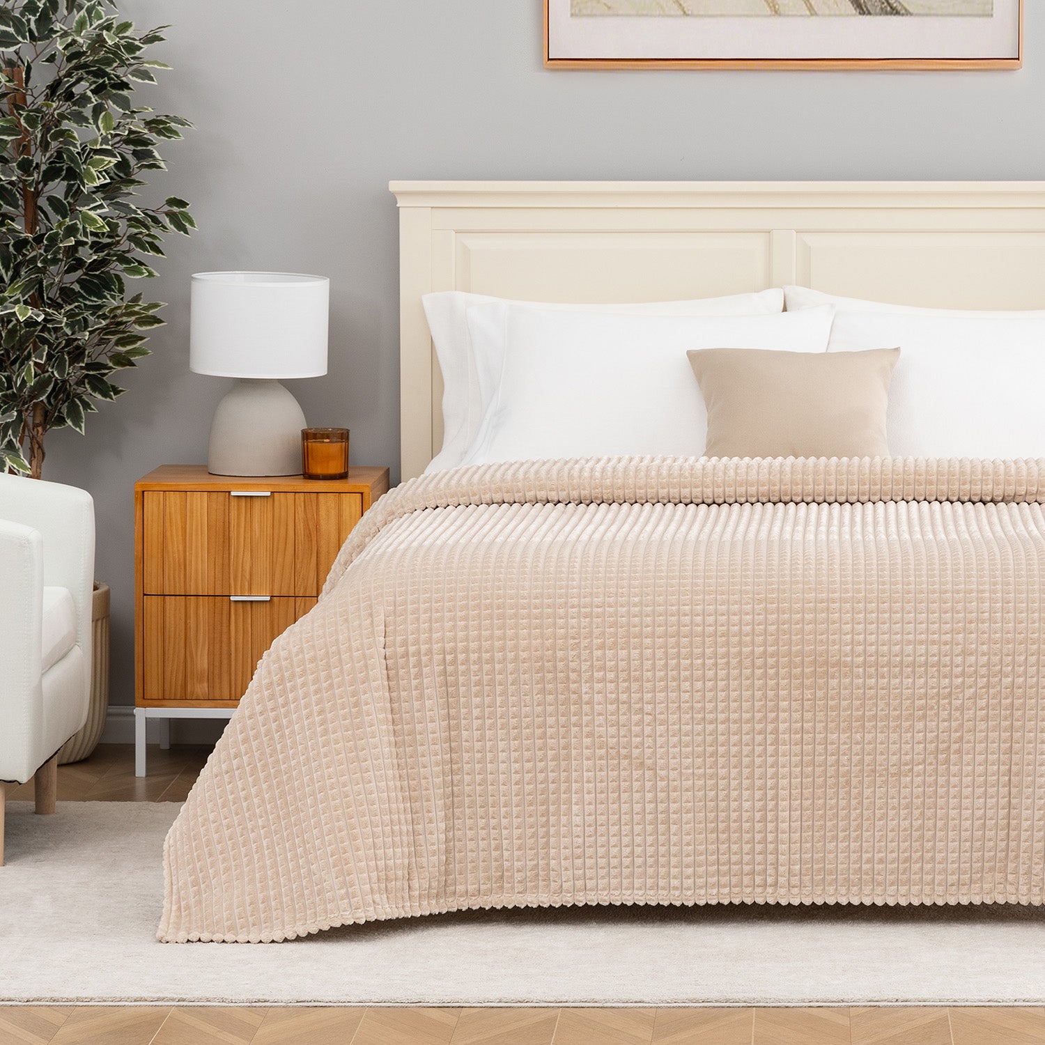 A tan waffle blanket decorated neatly on a bed.