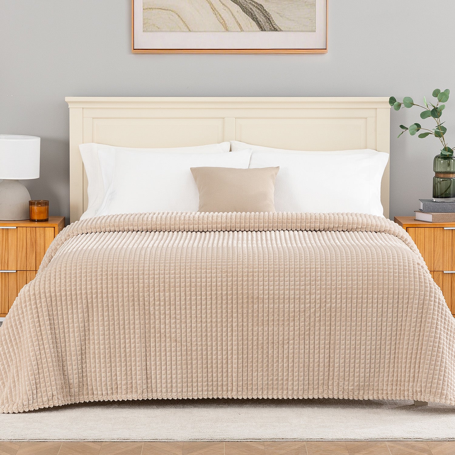 A tan waffle blanket decorated neatly on a bed.