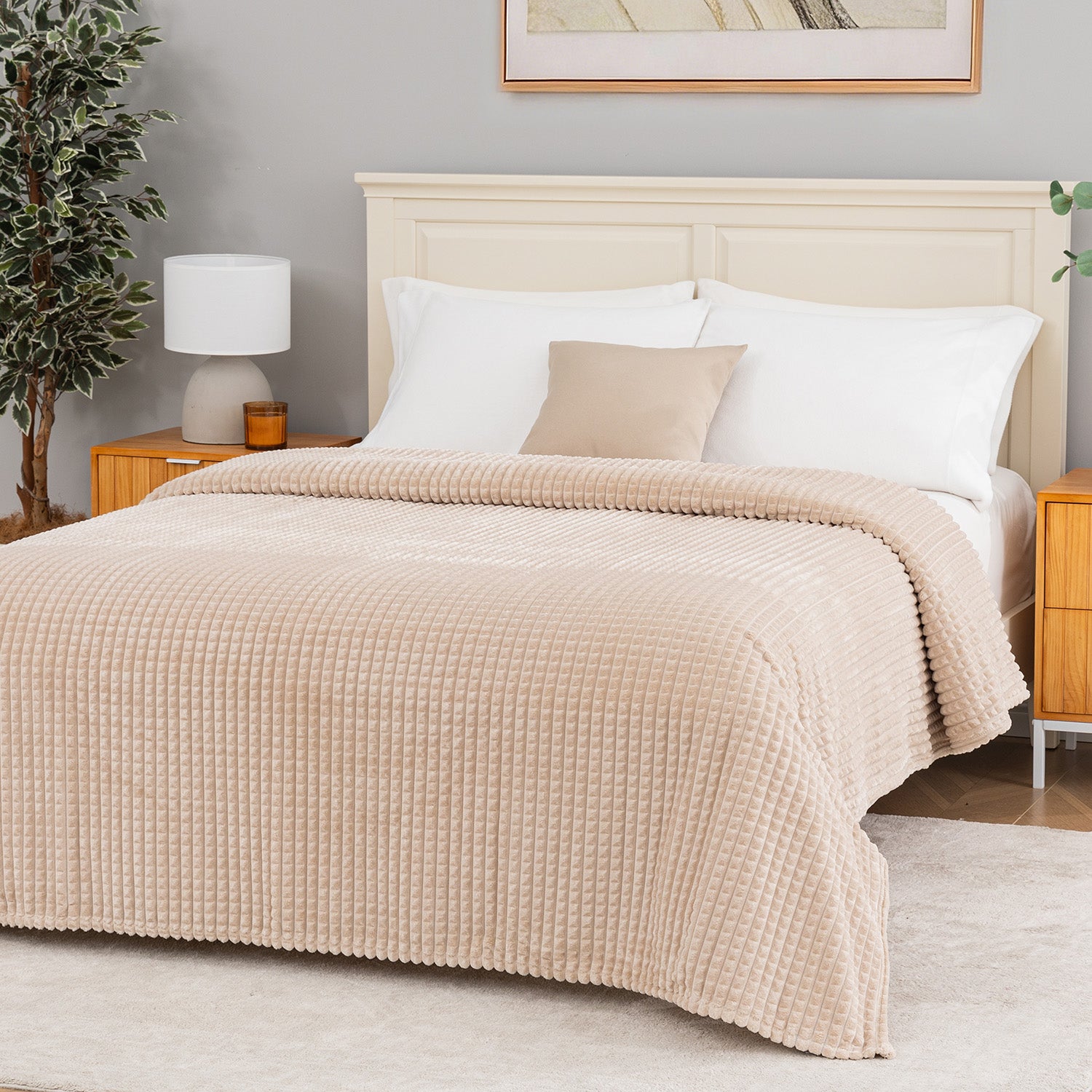 A tan waffle blanket decorated neatly on a bed.