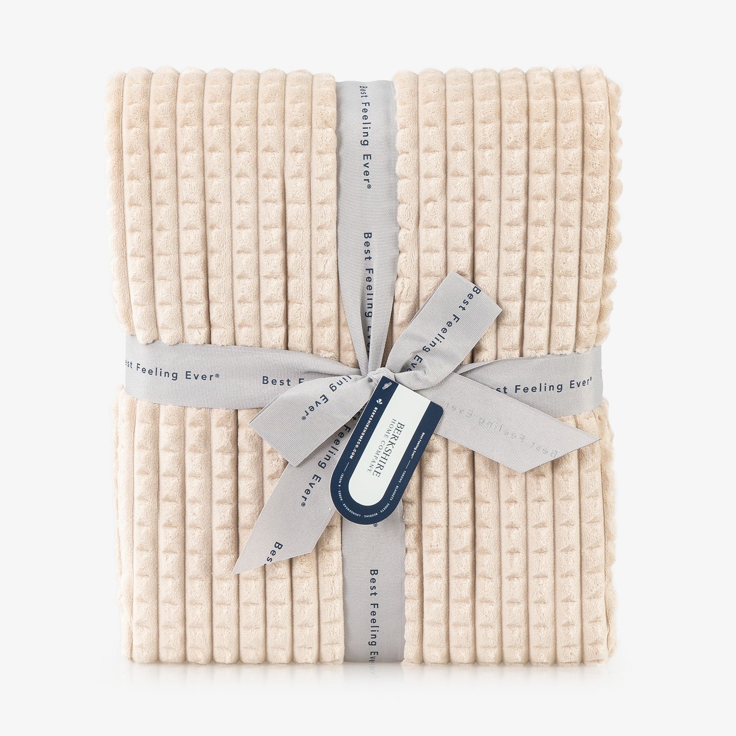 A tan waffle blanket folded neatly on a white surface.