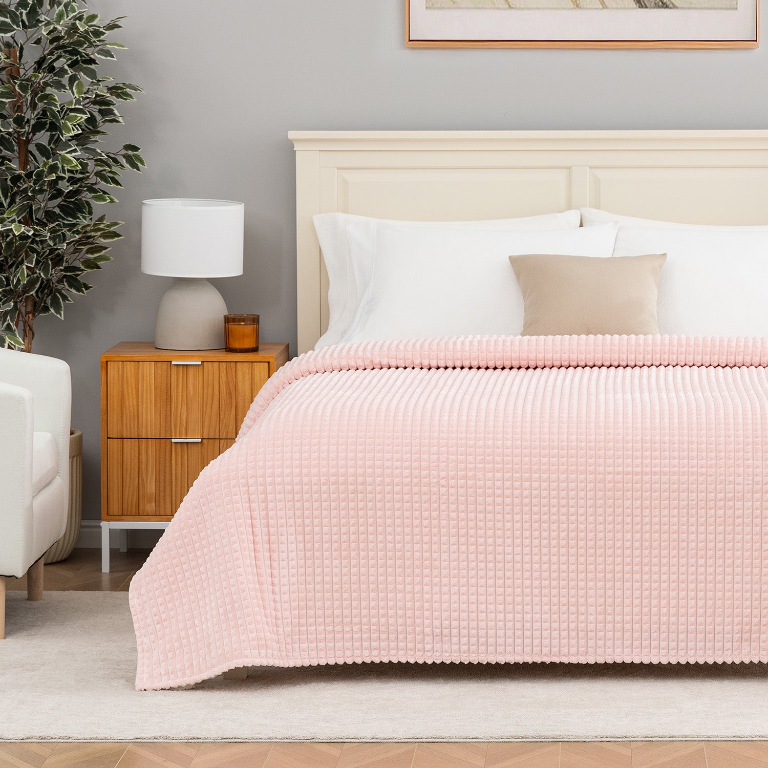 Pink textured blanket decorated neatly on a bed.