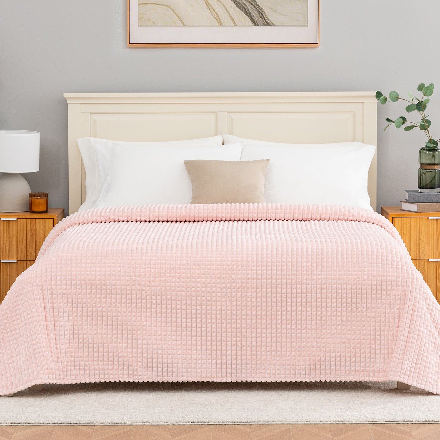 Pink textured blanket decorated neatly on a bed.