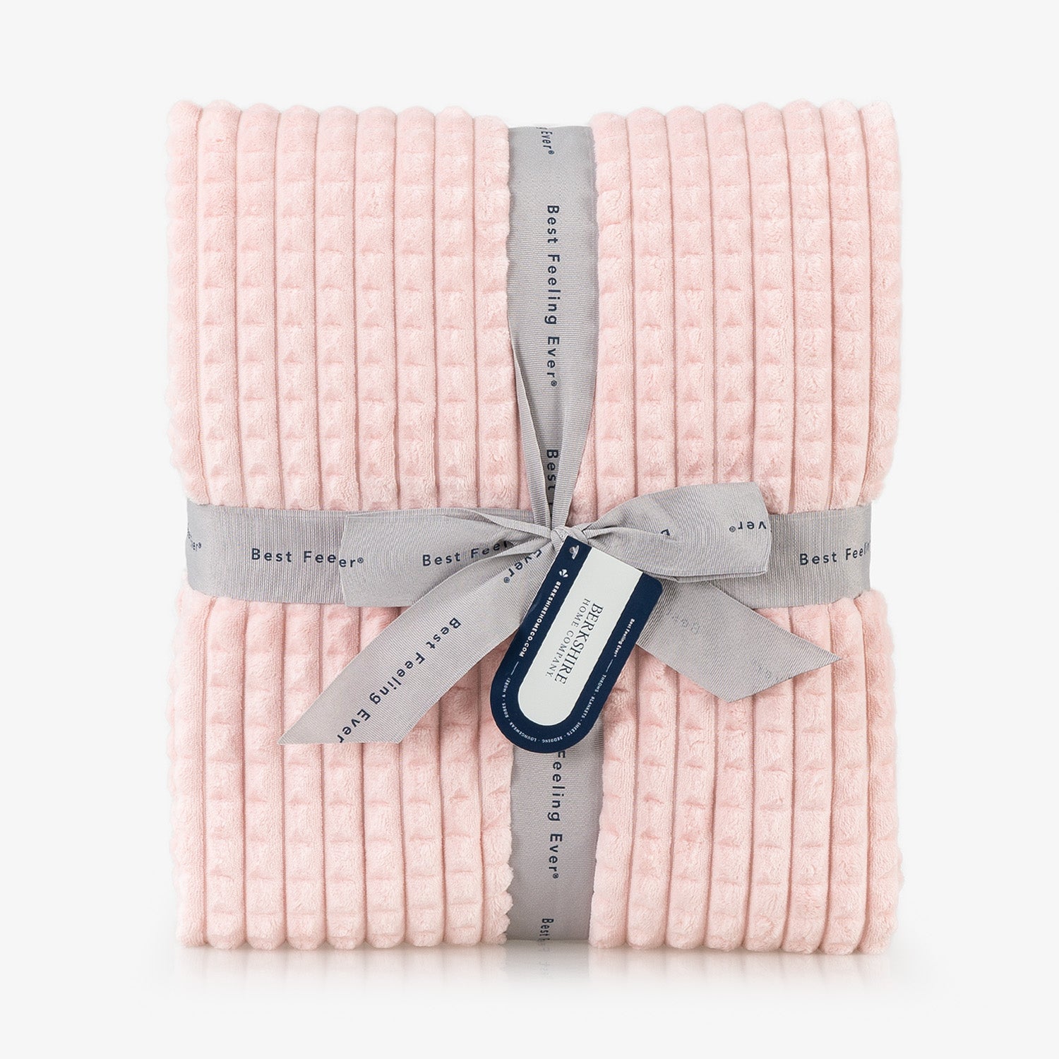 A pink waffle blanket folded neatly on a white surface.