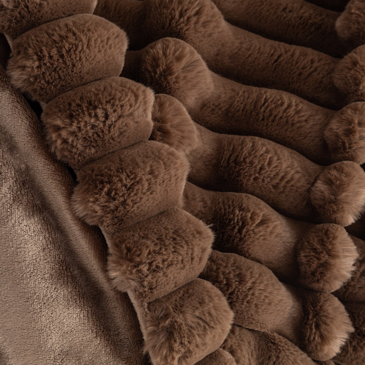 Close-up of a brown textured blanket with plush surface