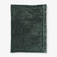 Folded dark green textured blanket on a white background