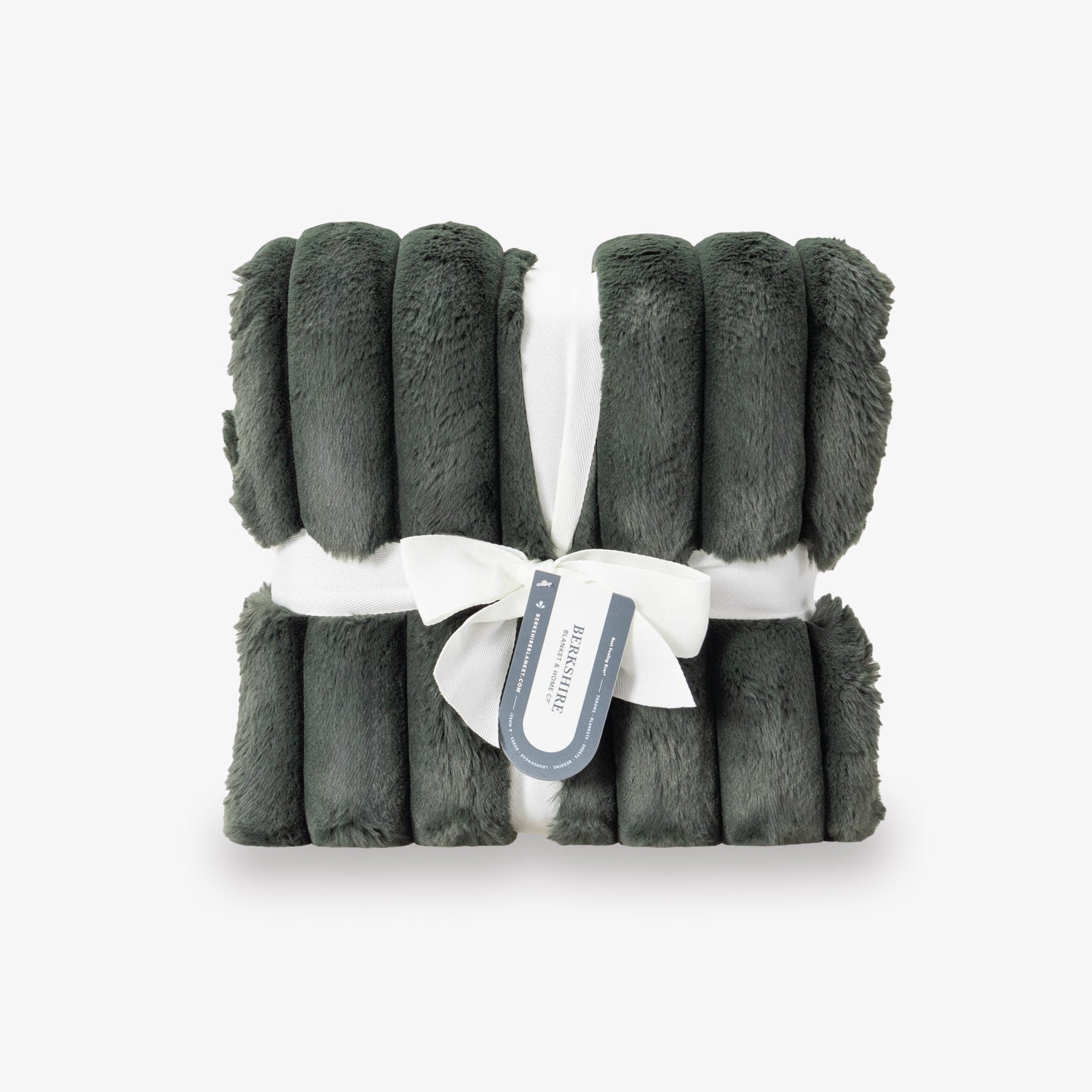 Green plush blanket with a white ribbon and label on a light gray background