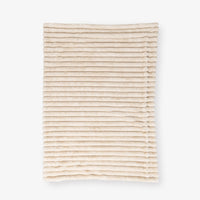 Beige textured throw laid flat on a white background
