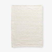 White textured throw laid flat on a white background