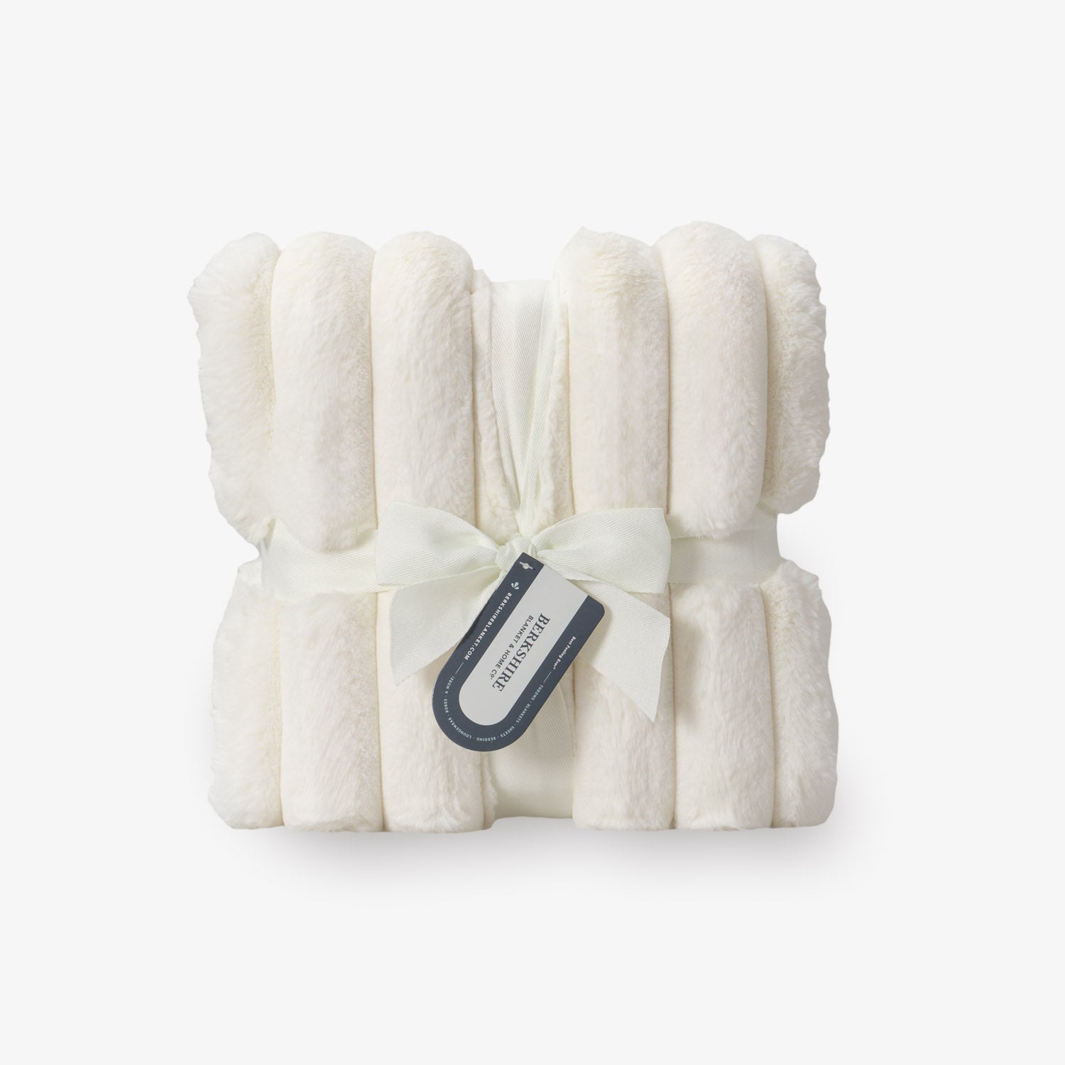 Folded white blanket with a tag on a light gray background