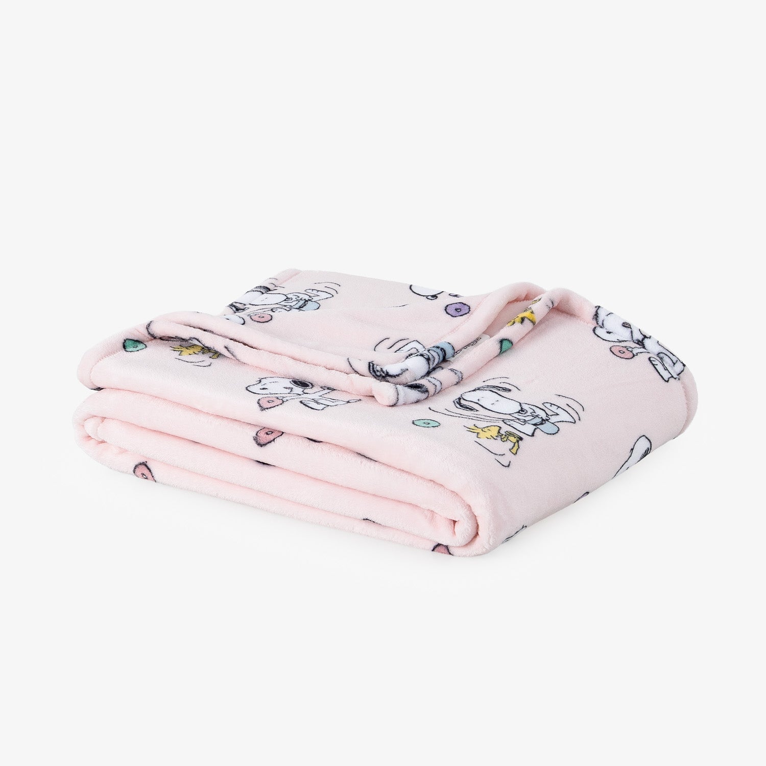 A light pink fleece throw blanket with a cartoon Snoopy and Woodstock print, folded neatly on a white surface.