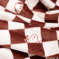 Brown and white checkered plush blanket with cartoon dog peeking out from the squares, shown in a close-up folded view.