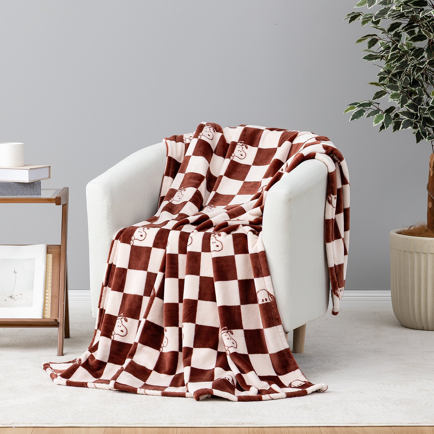 A checkered snoopy throw draped over a beige chair.