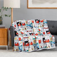 A multicolor Peanuts comic strip print throw blanket draped over a gray sofa in a modern living room setting.