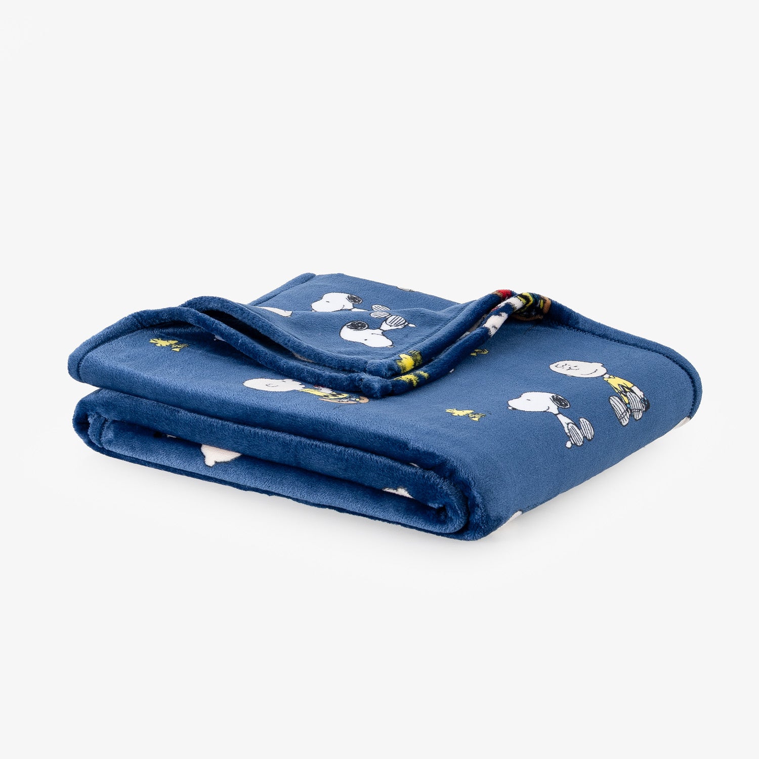 A blue peanuts throw folded neatly on a white surface.
