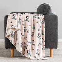 Blanket with cartoon character pattern draped over a gray chair.