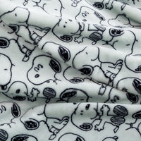 White plush fabric with an all-over black line-art print of Snoopy in various poses, shown in soft folds.