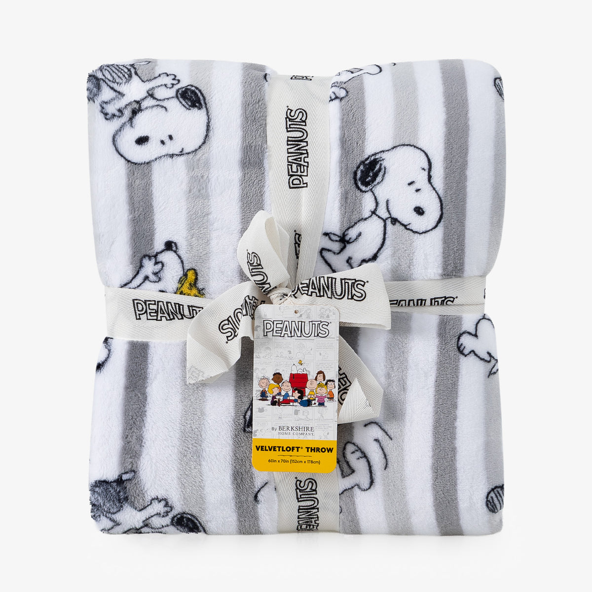 A folded Peanuts plush throw blanket with a white and gray striped pattern and cartoon character prints, tied with a white ribbon and tag.