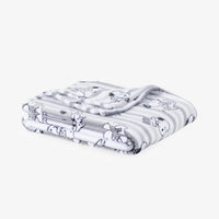 A folded white blanket with gray stripes and a cartoon dog pattern, shown on a light gray background.