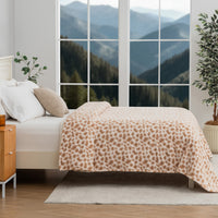 Bedroom with leopard print blanket, wooden nightstand, and mountain view.