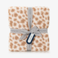 Cheetah print blanket with a gray ribbon and tag on a white background
