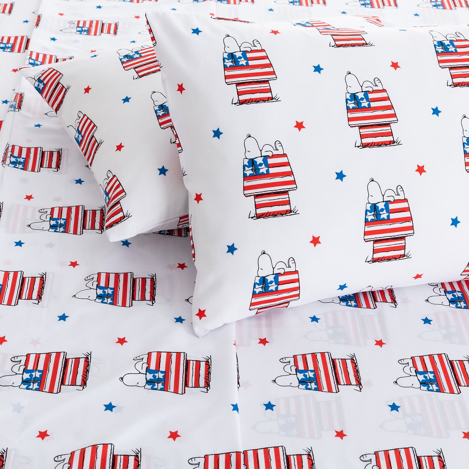 Peanuts-themed bedding set with Snoopy and Woodstock holding American flags on a white background.