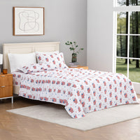 Bed with American flag patterned bedding in a room with a window and abstract art on the wall.