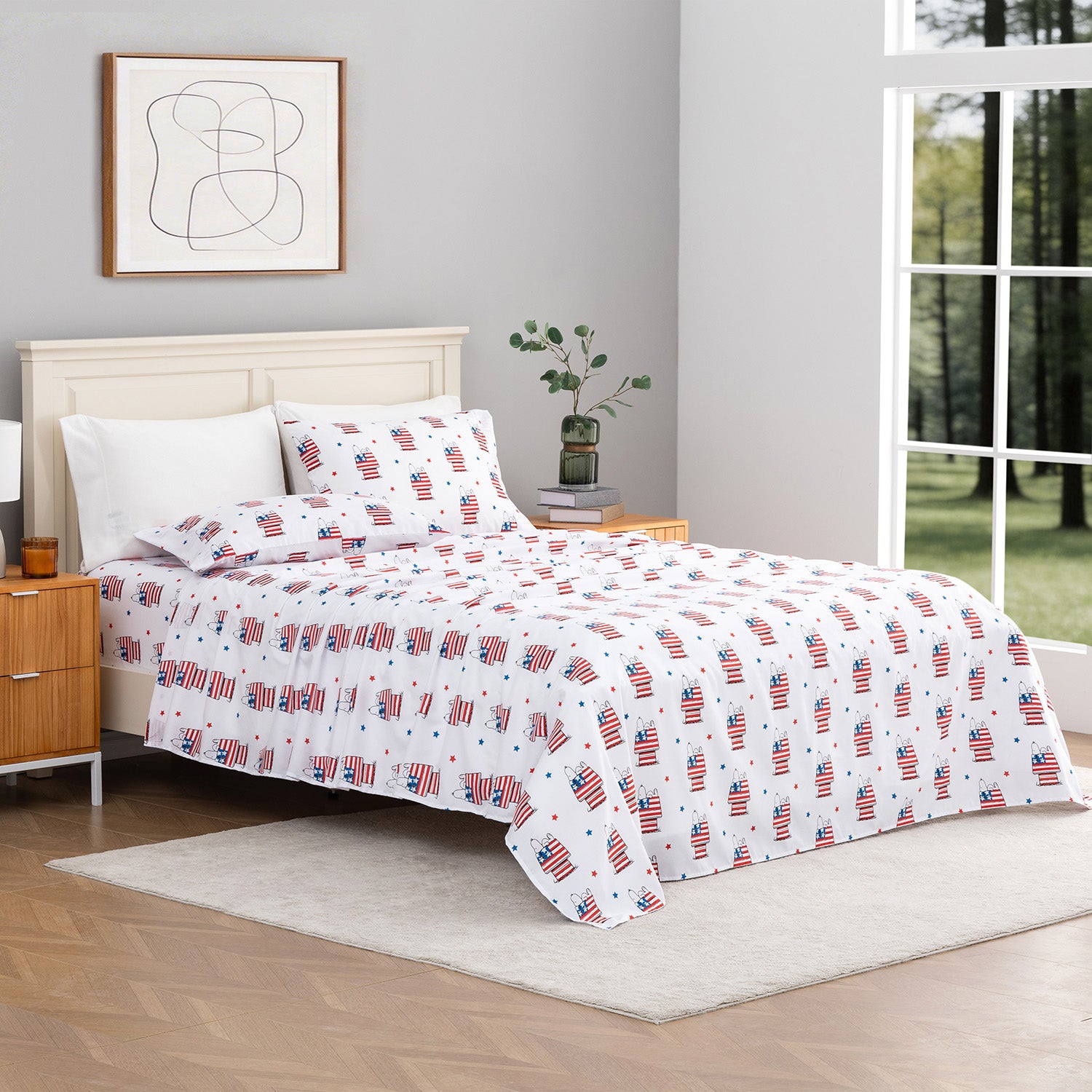Bed with American flag patterned bedding in a room with a window and abstract art on the wall.