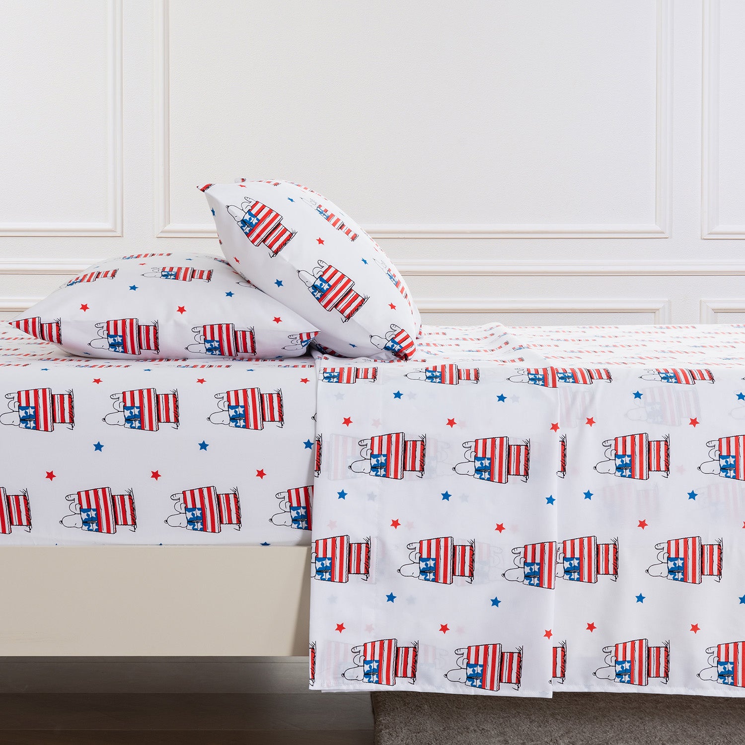 Bedding set with American flag pattern on a bed in a room.