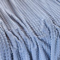 A close up of a blue waffle blanket.