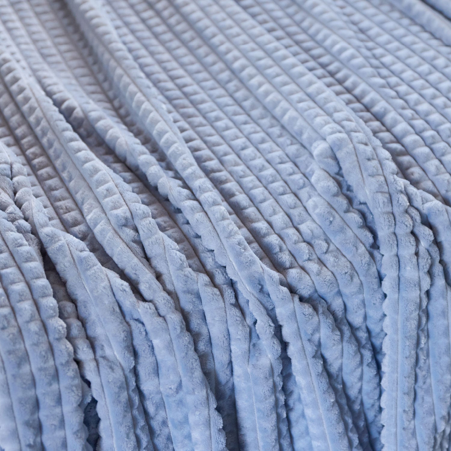 A close up of a blue waffle blanket.