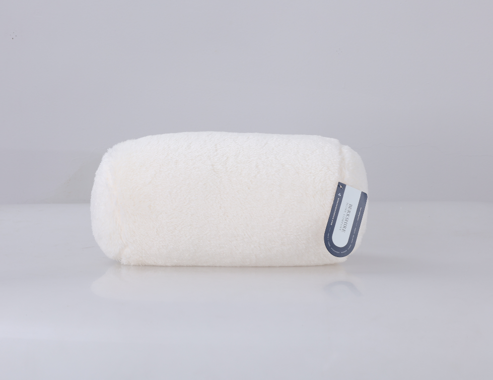 White cylindrical pillow with a label on a light gray background