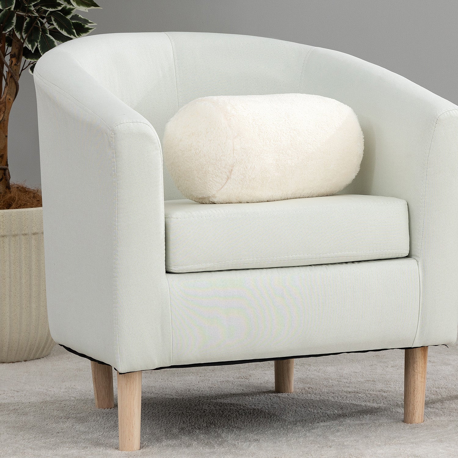 White armchair with a cushion on a gray background