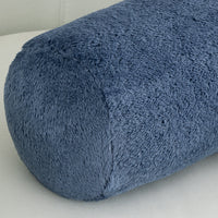 Blue textured cylindrical pillow on a light gray background