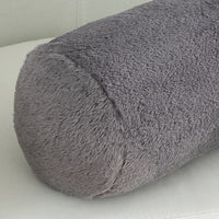 Gray textured cylindrical pillow on a light gray background